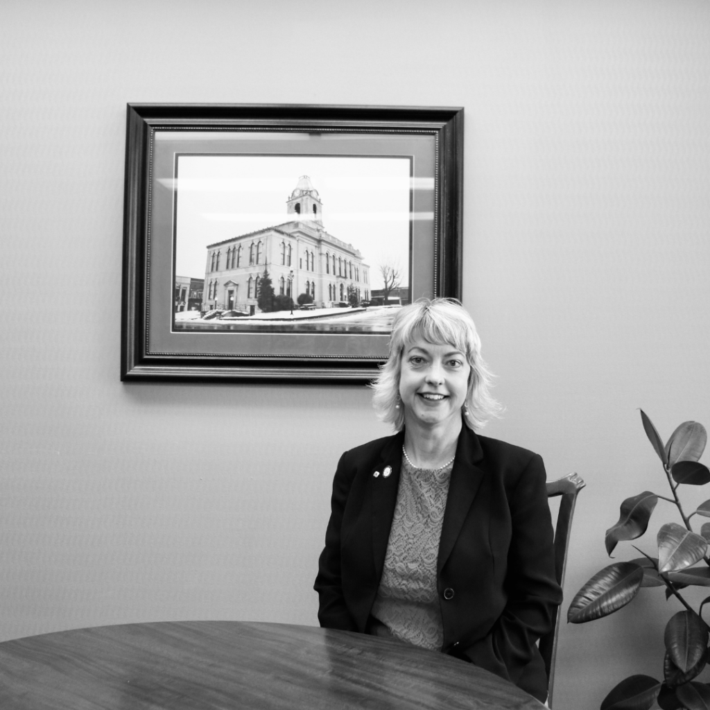 Ann Schneider-Williams in front of a picture of the Springfield, Tennessee courthouse.