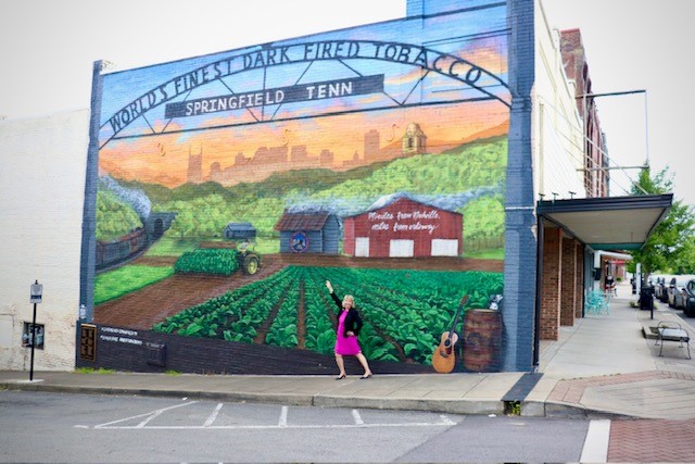 Ann Schneider-Williams in front of the Springfield, Tennessee mural. 