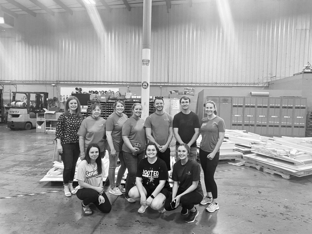 Brown and other employees from The Farmers Bank painting playhouses with Habitat for Humanity. Brown is pictured 4th from the left on the top row. 